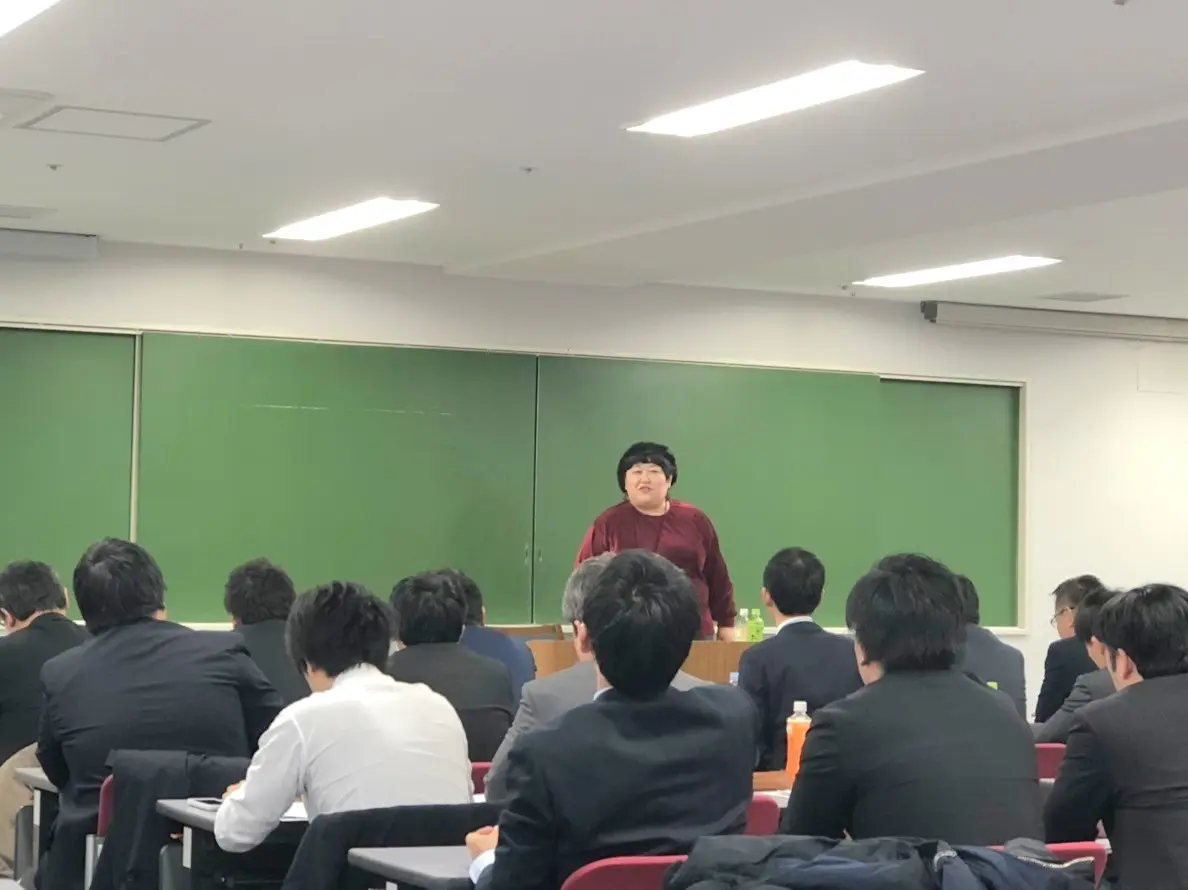 研修会場で参加者に向けて説明する講師
